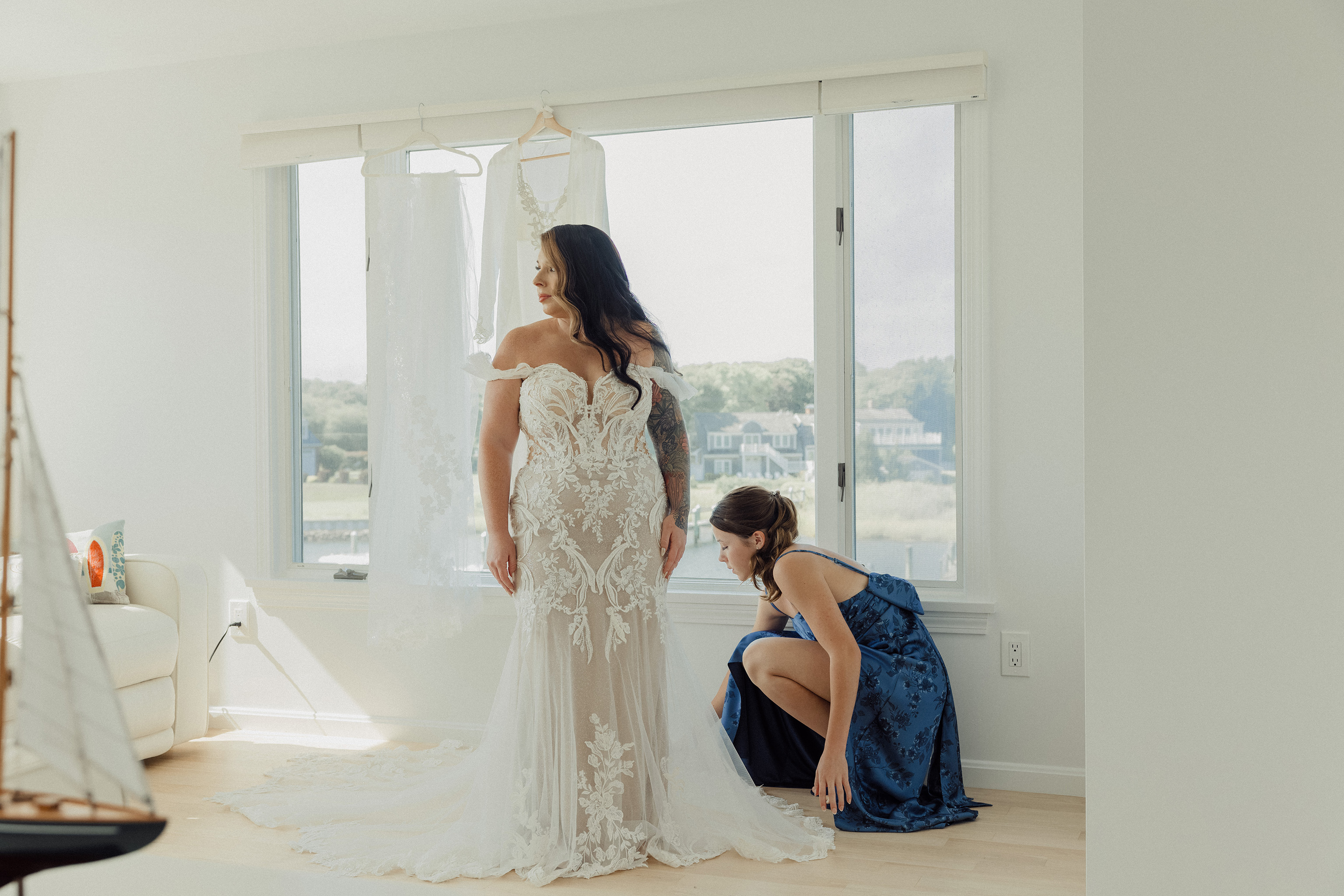 Bridal portrait during final gown adjustments in a sunlit room